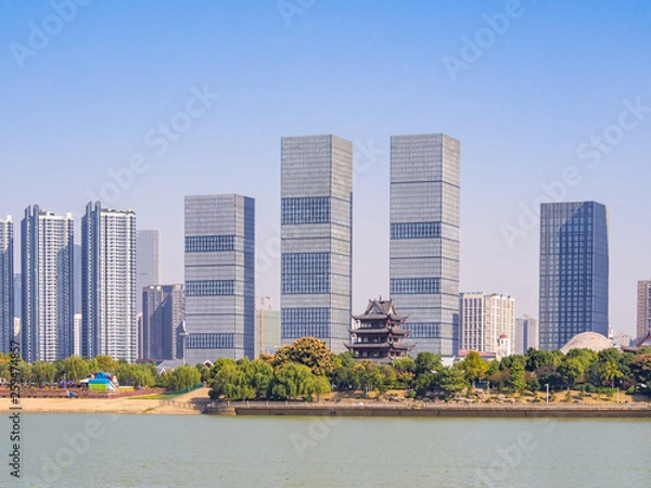 Obraz View at the bank of Xiang river in Changsha, the main city of Hunan Province, China. There are tall modern buildings, as well as traditional pavillion standing beside. Asian cityscape on a sunny day.