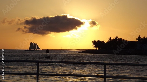 Fototapeta Ship with Sun behind clouds