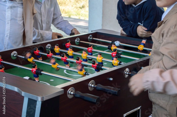 Fototapeta Niños jugando futbolito en recreo.