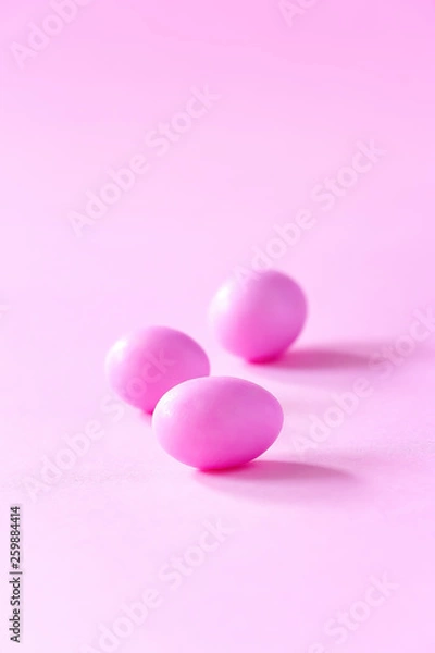 Obraz Three small pink candy eggs on pink background. Easter celebrate concept. Copy space.