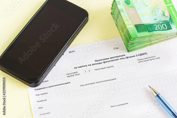 Obraz Document in Russian language "of the Tax Declaration on the tax to incomes of physical persons" close-up, pen, smartphone and money for the payment of tax