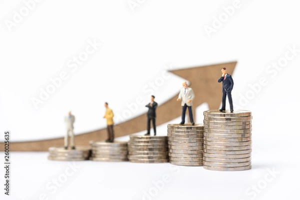 Fototapeta Miniature peolple, businessman on coins stack with arrow wooden icon. Concept of business decision,making deal, signing contract,money saving, financial,insurance, business plan.