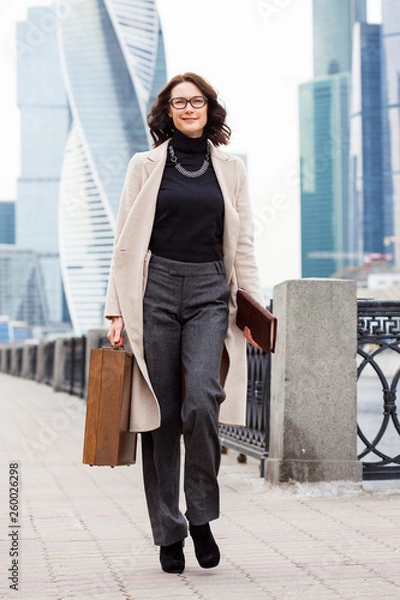 Obraz Beautiful middle-aged business woman with a small suitcase in hand