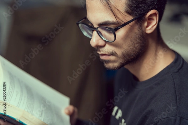 Fototapeta Young computer science student reads an advanced robotics book in Caceres, Spain.