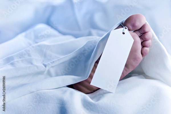 Obraz Feet of a dead body, identification tag, close-up in white sheets