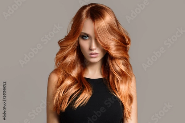 Obraz Piękna kobieta z długimi falującymi włosami farbowanie. Płaskie szare tło.