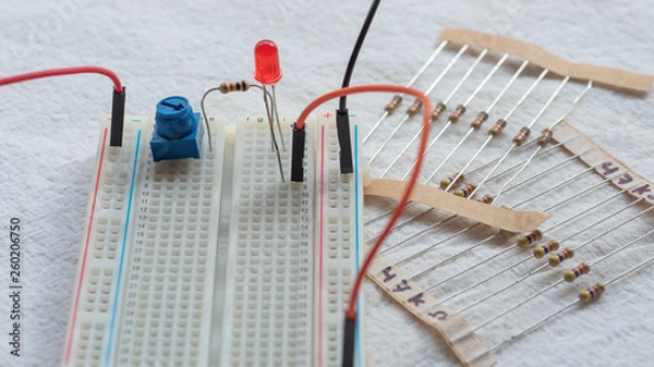 Obraz Potentiometer, resistors and red LED set up on a breadboard 