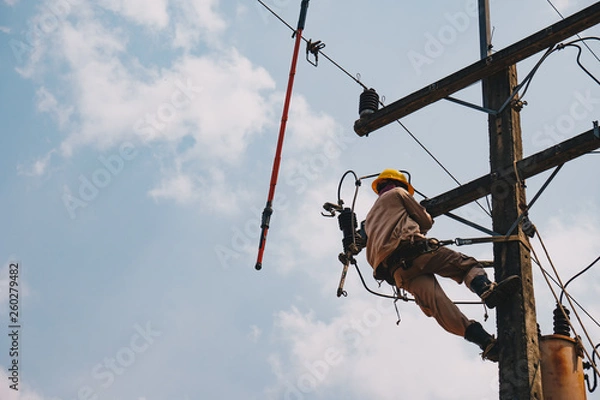 Fototapeta The power lineman uses insutated tool to open the connection of the transformer from the high voltage distribution system. To change the surge arrester that protects the transformer.