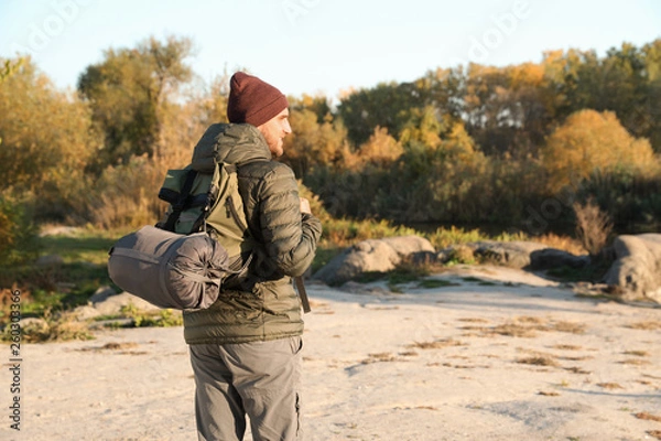 Obraz Male camper with backpack and sleeping bag in wilderness. Space for text
