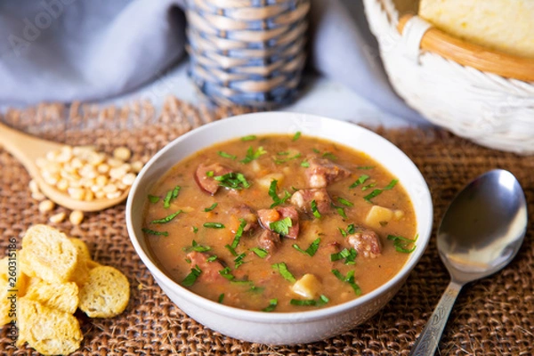 Obraz Peas soup with meat, smoked sausage and croutons. Selective focus, close-up.