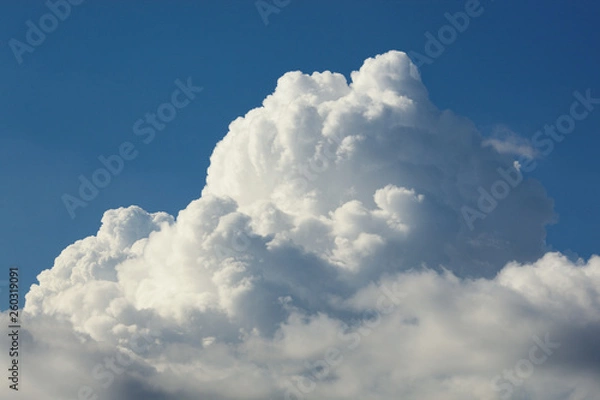 Obraz White top of a thundercloud against a blue sky close-up.