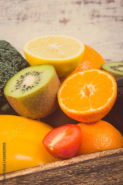 Fototapeta Heap of ripe fruits with vegetables in rustic box. Nutritious food containing healthy minerals and vitamins. Vintage photo