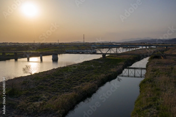 Fototapeta 夕暮れの渡良瀬川とローカル列車