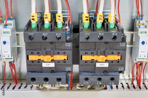 Fototapeta Electrical cables and wires are connected to two powerful magnetic starter or contactor. On the sides of the modular time relay with adjustment. Electrical equipment in the electrical Cabinet.