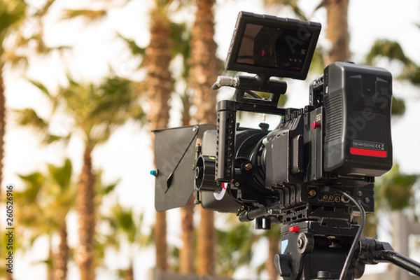 Fototapeta Movie camera on set in exterior with palm trees