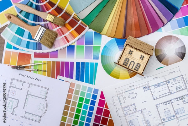 Fototapeta Close up of wooden house model with blueprint and color swatches