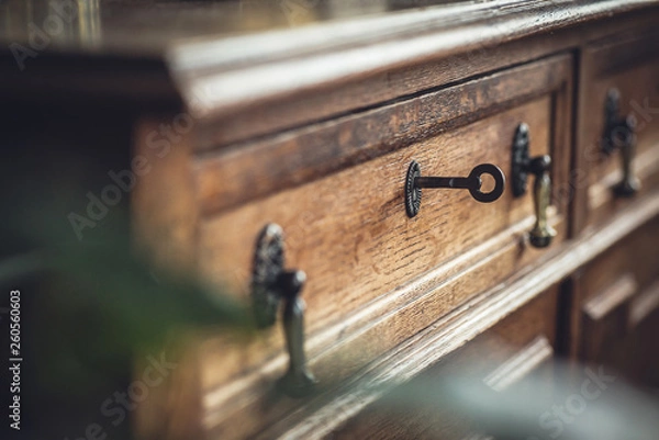 Fototapeta Vintage. Old chest of drawers with a key in the keyhole. Shallow DOF