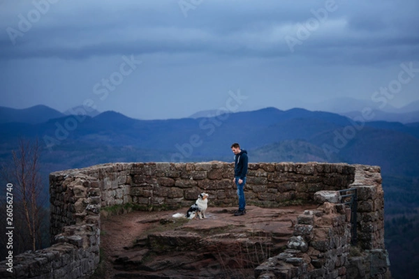 Obraz man and dog travel together. Pet and his friend in nature. Australian Shepherd and its owner