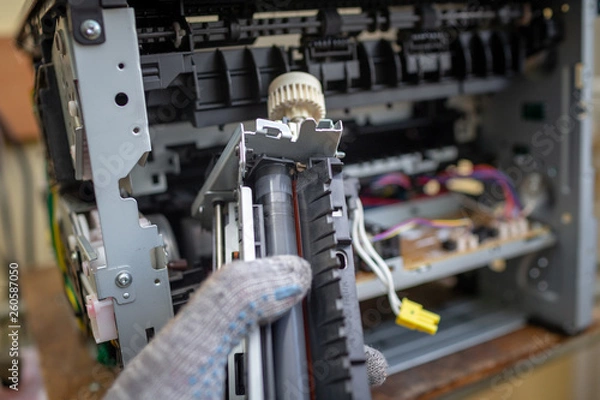 Obraz Specialist repairs laser printer. Worn and torn thermal film. Faulty thermal node