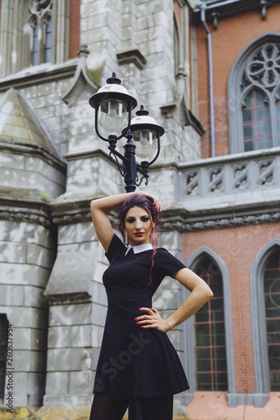Fototapeta Young brunette girl in gothic style on a background architecture