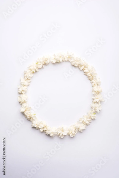 Fototapeta Jasminum sambac or Mogra Flower arranged in a  circular or rectangular  frame shape over white background, selective focus