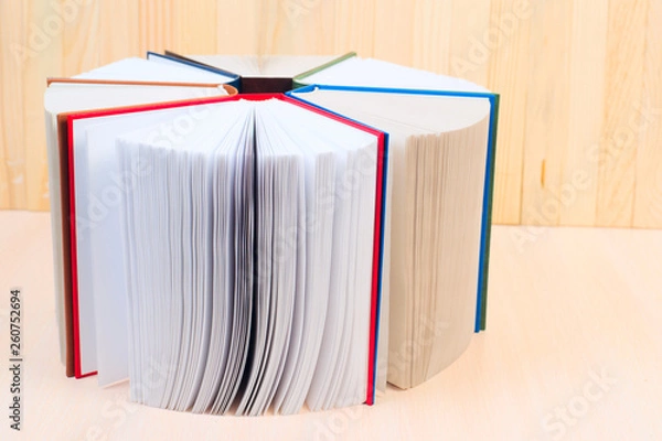 Obraz Open book, stack of hardback books on wooden table. Back to school. Copy space