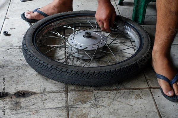 Fototapeta Motorcycle repair after a tire leak 