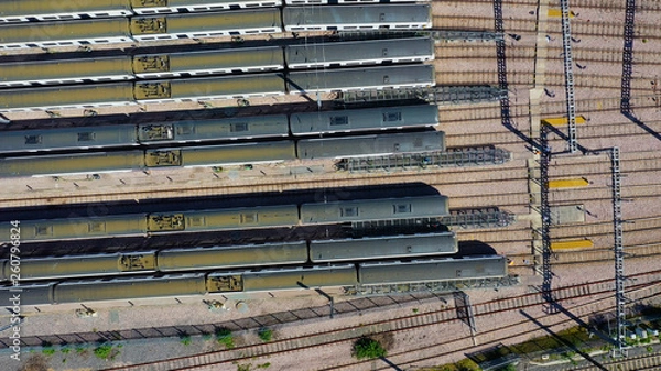 Fototapeta Aerial view over passenger trains in rows at a station