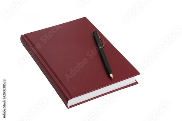 Fototapeta The burgundy notebook and black pen lie on a white table.