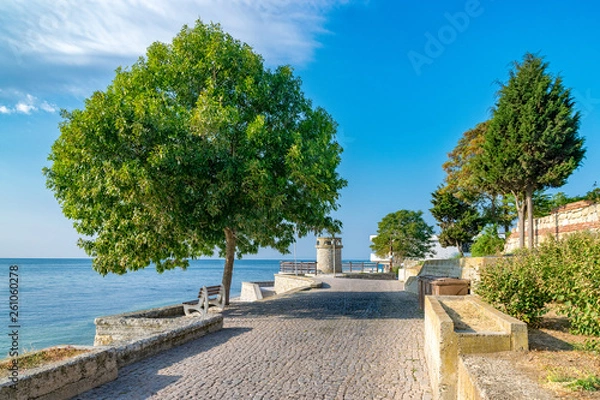 Fototapeta A beautiful street in Nessebar ancient city on the Bulgarian Black Sea Coast. Nesebar or Nesebr is a UNESCO World Heritage Site. A street in Nessebar on a sunny day with blue sky, Bulgaria