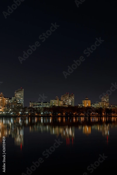 Fototapeta illuminated buildings with reflection on water at night