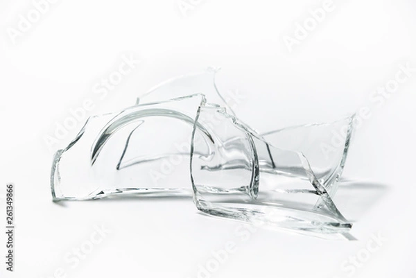 Fototapeta Parts of the broken cup jar glass isolated on white background. Pieces of sharp broken glass. Concept of danger.