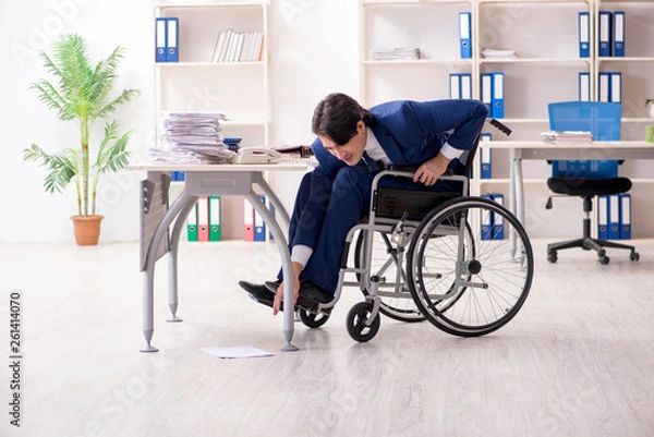 Fototapeta Young male employee in wheelchair working in the office 