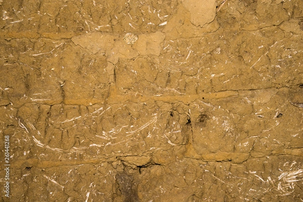 Fototapeta Adobe brick wall with worn-off plaster