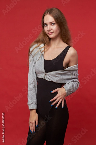 Obraz Pretty young sexy fashion sensual woman posing on red wall background,dressed in hipster outfit, stylish trendy brunette hipster in black clothes.Red background, not isolated
