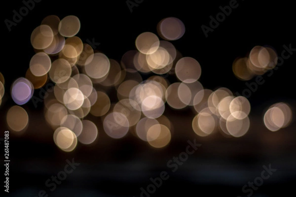 Fototapeta Abstract light blurred bokeh on dark background.