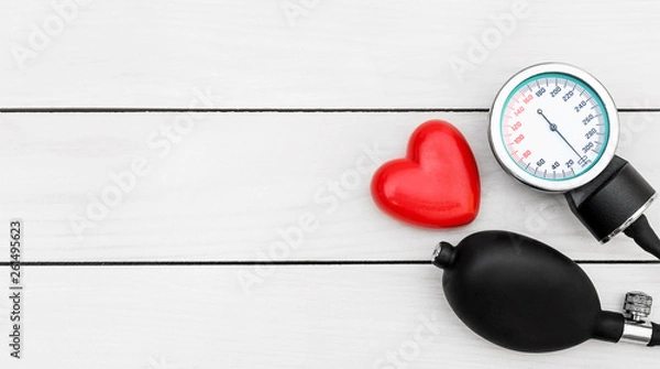 Fototapeta Manometer for measuring blood pressure with red heart on wooden background.