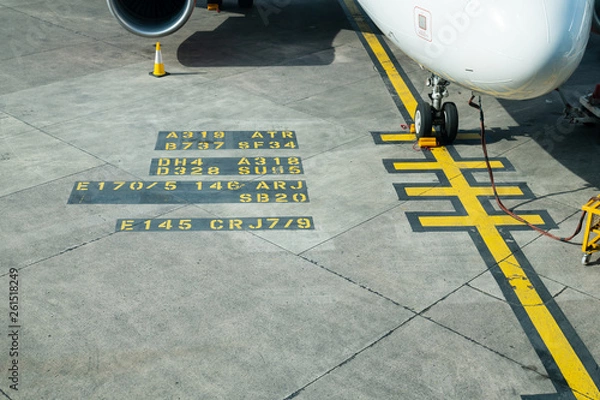 Fototapeta Text written out on the tarmac of a Runway at Manchester Airport, UK