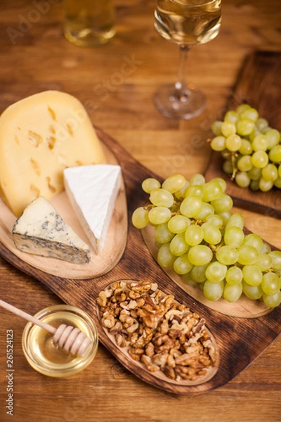 Obraz Top view of tasty walnuts next to fresh grapes on wooden plate
