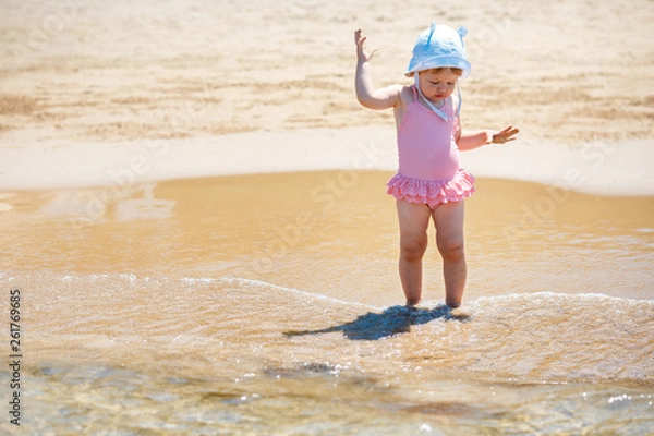 Fototapeta Adorable little girl playing on tropical beach. Travel with young children