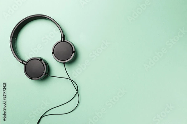 Fototapeta Headphones on Mint background. Black headphones on a pastel background. Top view. Flat lay. Copy space. Minimal style with colorful paper backdrop. Music concept. Neo Mint color of the year 2020