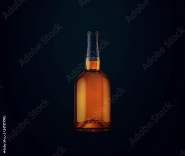 Obraz Full whiskey bottle on dark background. Product packaging brand design. Mock up drink with place for you lable and text. Old and tasty scotch whisky against lit background.