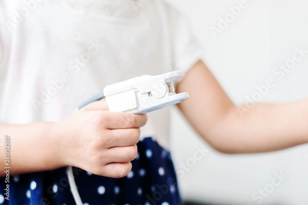 Fototapeta Fingertip Pulse Oximeter on finger of little baby child in hospital