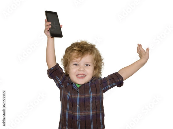 Obraz A little toddler boy picks up a smartphone gadget above his head. A satisfied child is happy that he was allowed to play phones with his smartphone.