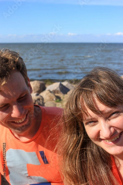 Obraz A couple of lovers sitting on boulders by the sea