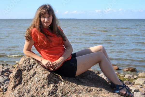 Obraz Girl sitting on a rock by the sea