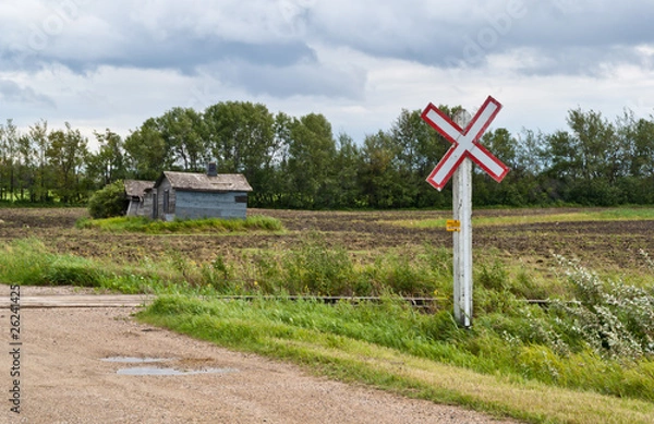 Fototapeta A sign marks a dirt road railway crossing on the prairies