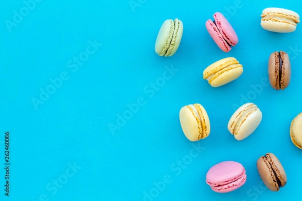 Fototapeta Brignt macarons for sweet break on blue background top view mock up