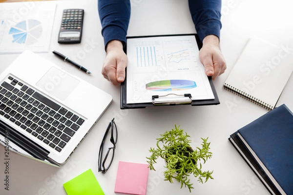 Fototapeta stock market chart and finger pointing on tablet in office