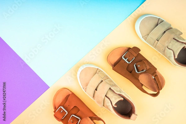 Fototapeta Sneakers and sandals on a trendy color background, top view, summer shoes.